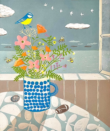 Lino print of a mug with blue dots filled with bright spring flowers and bluetit on them with an ocean scene behind for art licensing
